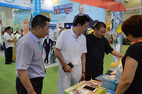 欧亚展览董事长王树民（左）与河南省民办教育协会副秘书长孟绍增（中）与展商亲切交谈